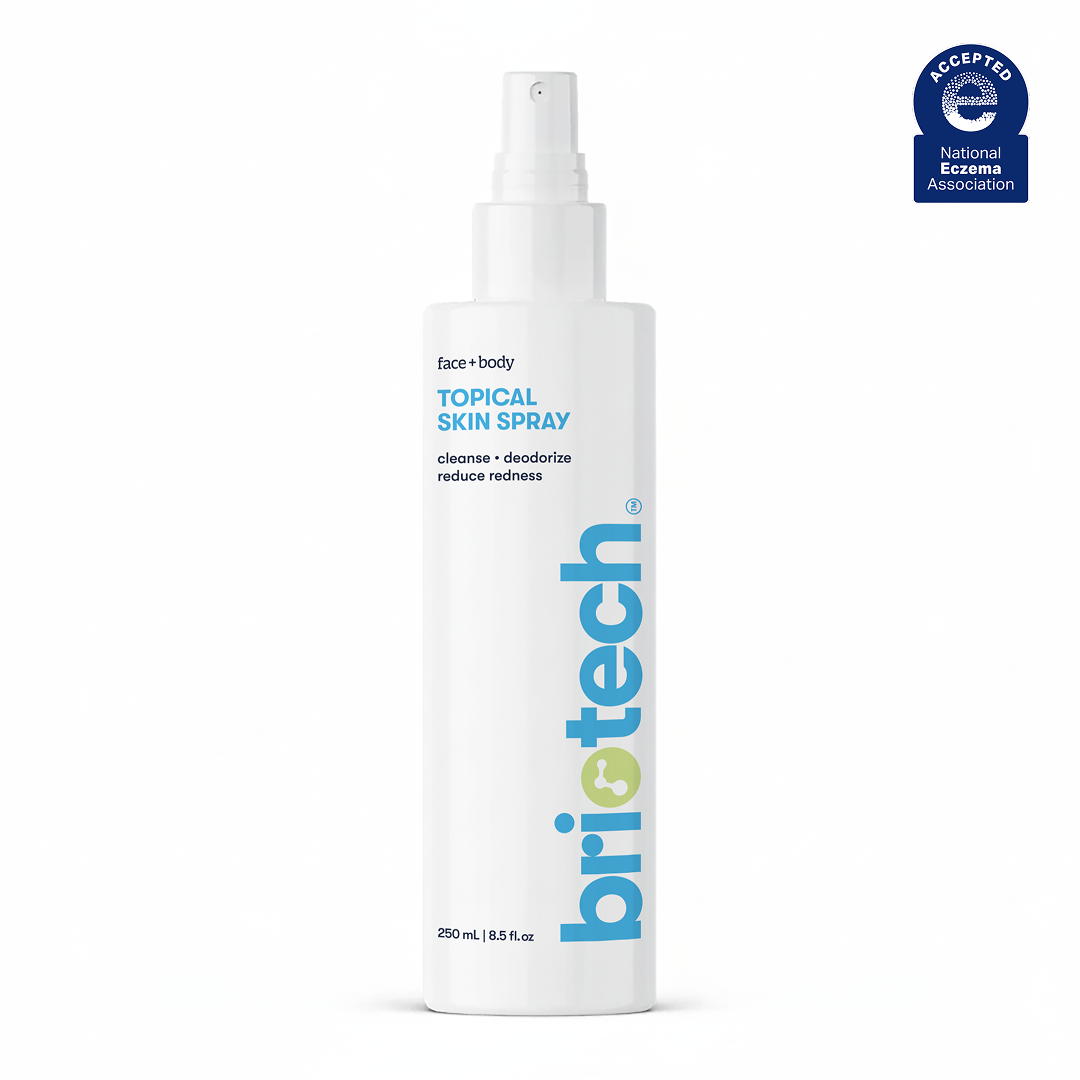 A white spray bottle labeled Topical Skin Spray for face and body, featuring blue and green text. This soothing spray cleanses, deodorizes, reduces redness, calms irritation, and comes in a 250 ml (8.5 fl oz) bottle.